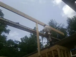 Carpenter setting a ridge beam over a new addition frame — Ice Dam Removal by Roofing Brothers in Tabor City