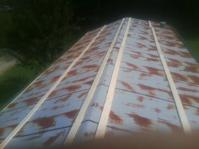Rusted metal roof panels with new wood purlins before replacement — Storm Damage Roof Repair in Tabor City by Roofing Brothers