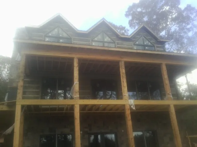 Dormers and porch framing on a large log home under construction — Roof Coating work by our crew in Tabor City