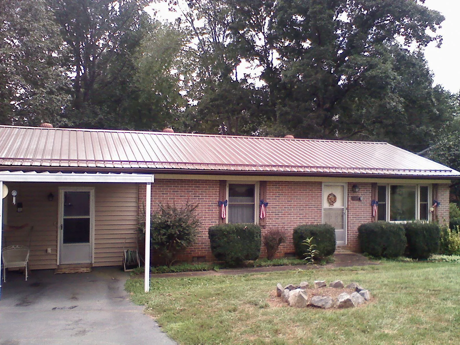 Bronze metal roof and carport on a brick ranch home — Roof Repair work by our crew in Tabor City